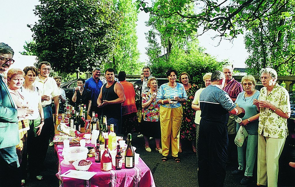 La fête des voisins en 2002, avec de nombreuses personnes âgées autour de la table, en extérieur