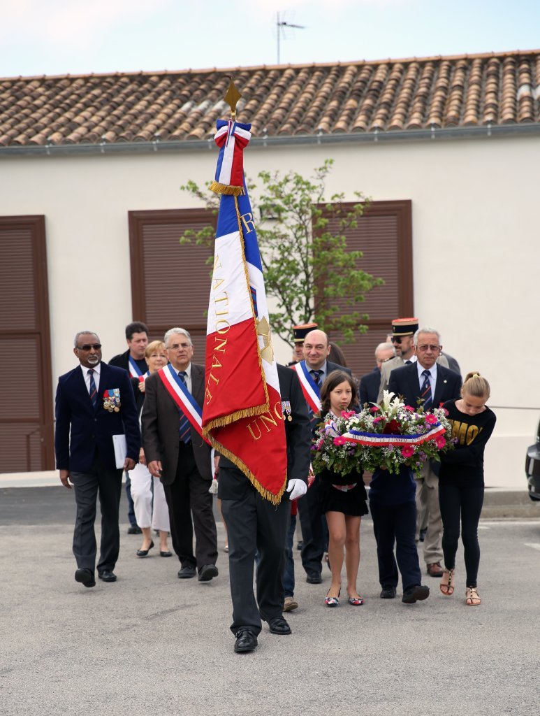 Une gerbe est déposée devant le monument aux morts.