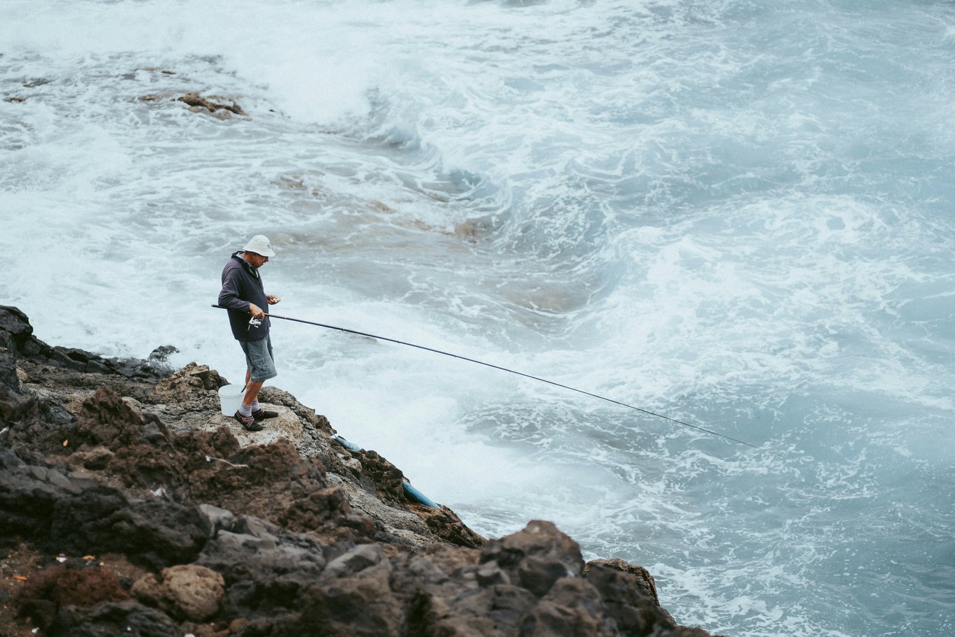 Pêcheur sur le rivage rocheux.