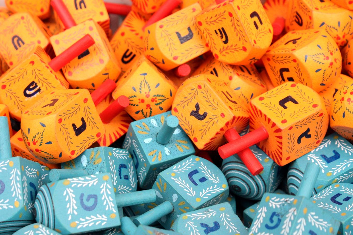 Collection de dreidels (toupies) de couleur, en vente au marché Mahane Yehuda de Jérusalem.<br />
Les bleus ont inscription pour Israël (נ ג ה פ) tandis que les oranges concernent la diaspora (נ ג ה ש).